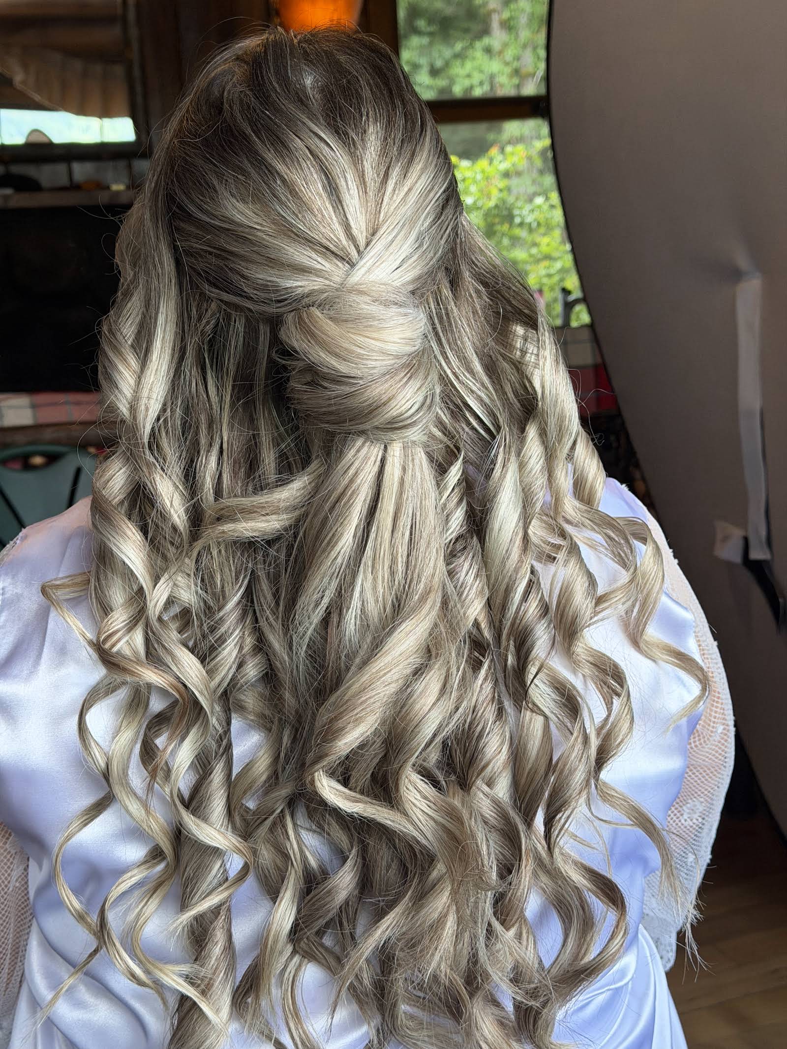 Half-up bridal hairstyle with braided crown and soft blonde waves, styled by Eleglam